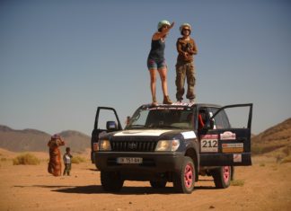 Mujeres compitiendo en el desierto paradas sobre su 4x4